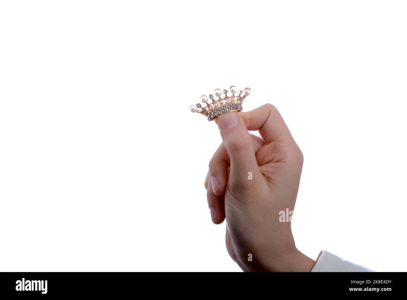 Golden color crown with pearls in hand on a white backgound Stock Photo