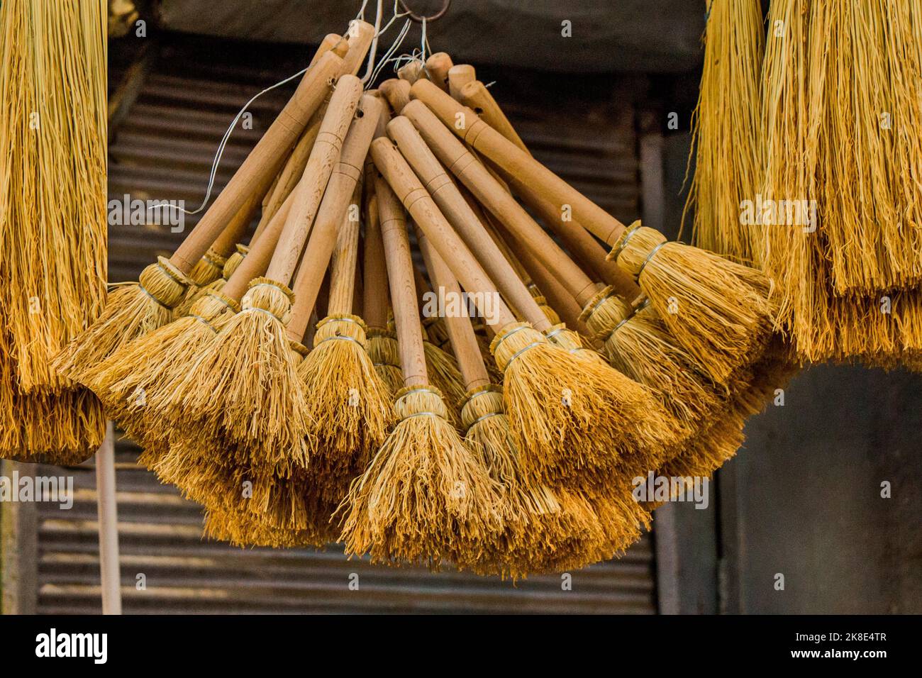 Set of yellow straw broom in a bazaar Stock Photo