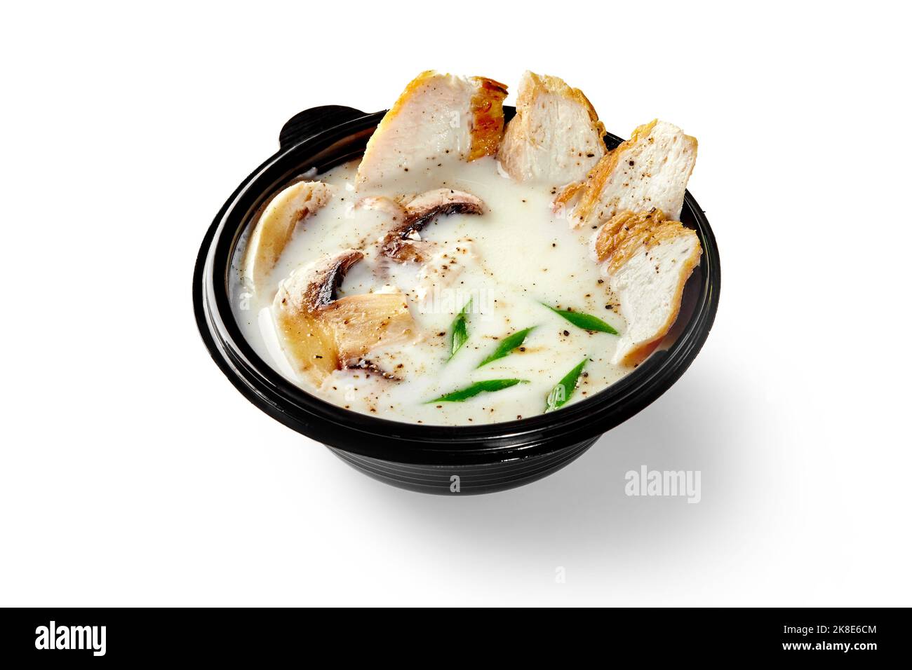 Thai soup tom kha gai with coconut milk, chicken, mushrooms and green