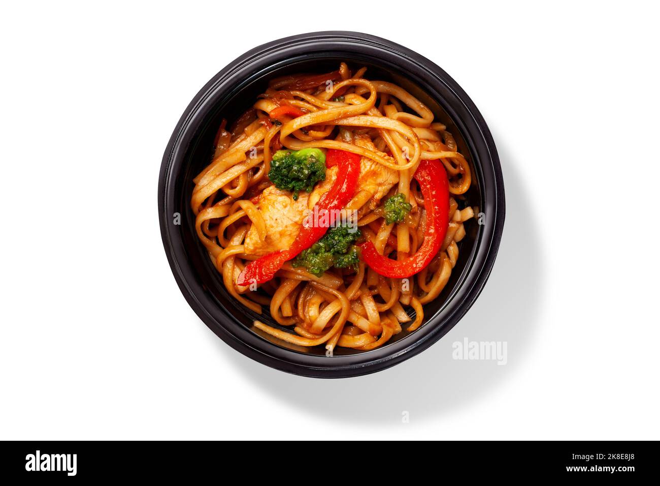 Bowl of Chinese udon noodles with stir fried chicken, bell peppers and