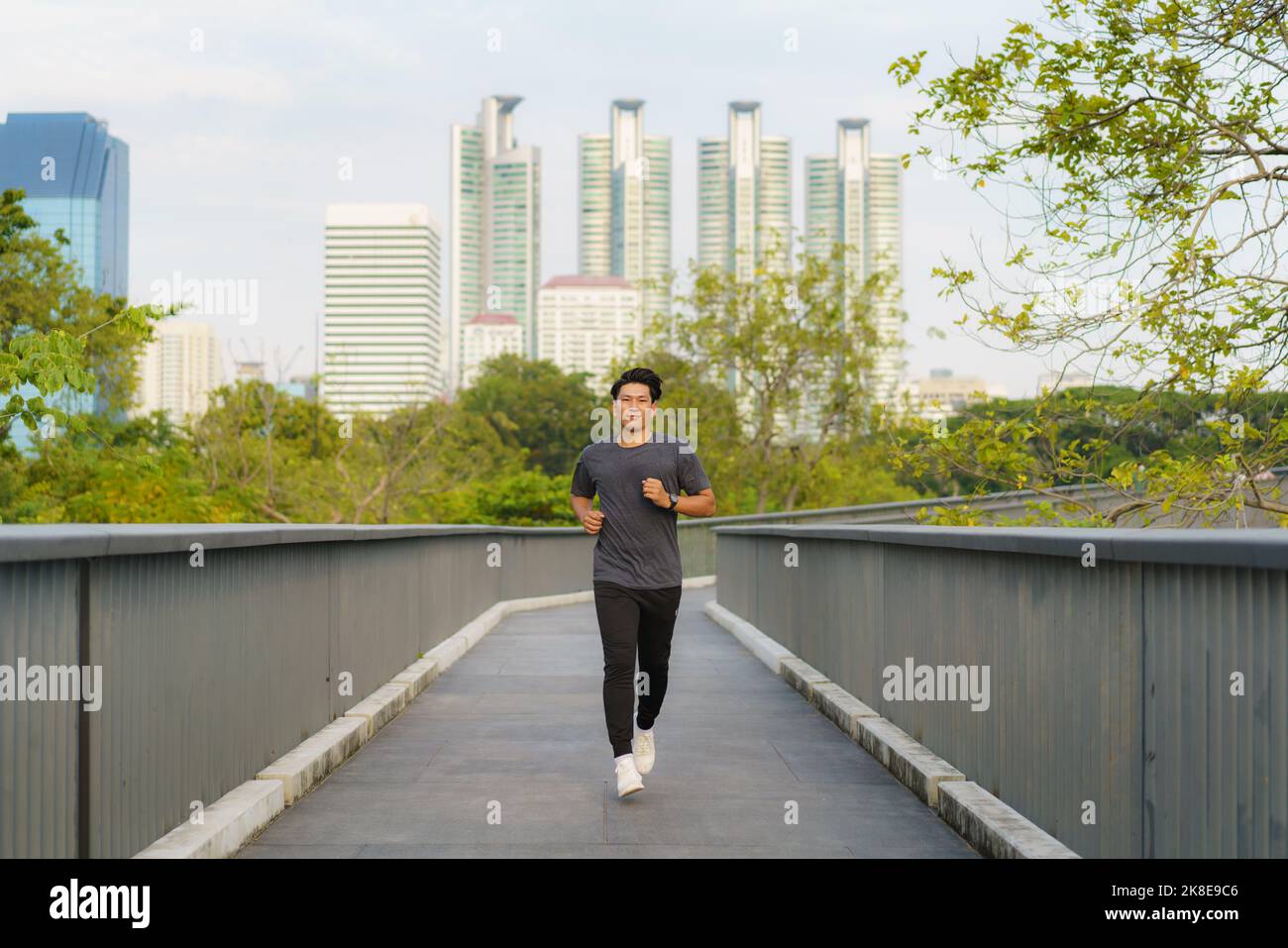 Asian healthy athlete man jogging at morning in public city park the city. Stock Photo