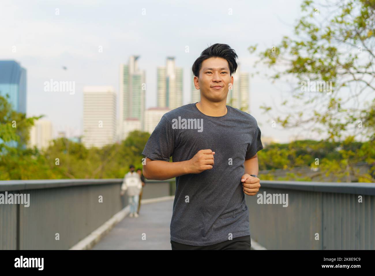 Asian healthy athlete man jogging at morning in public city park the city. Stock Photo