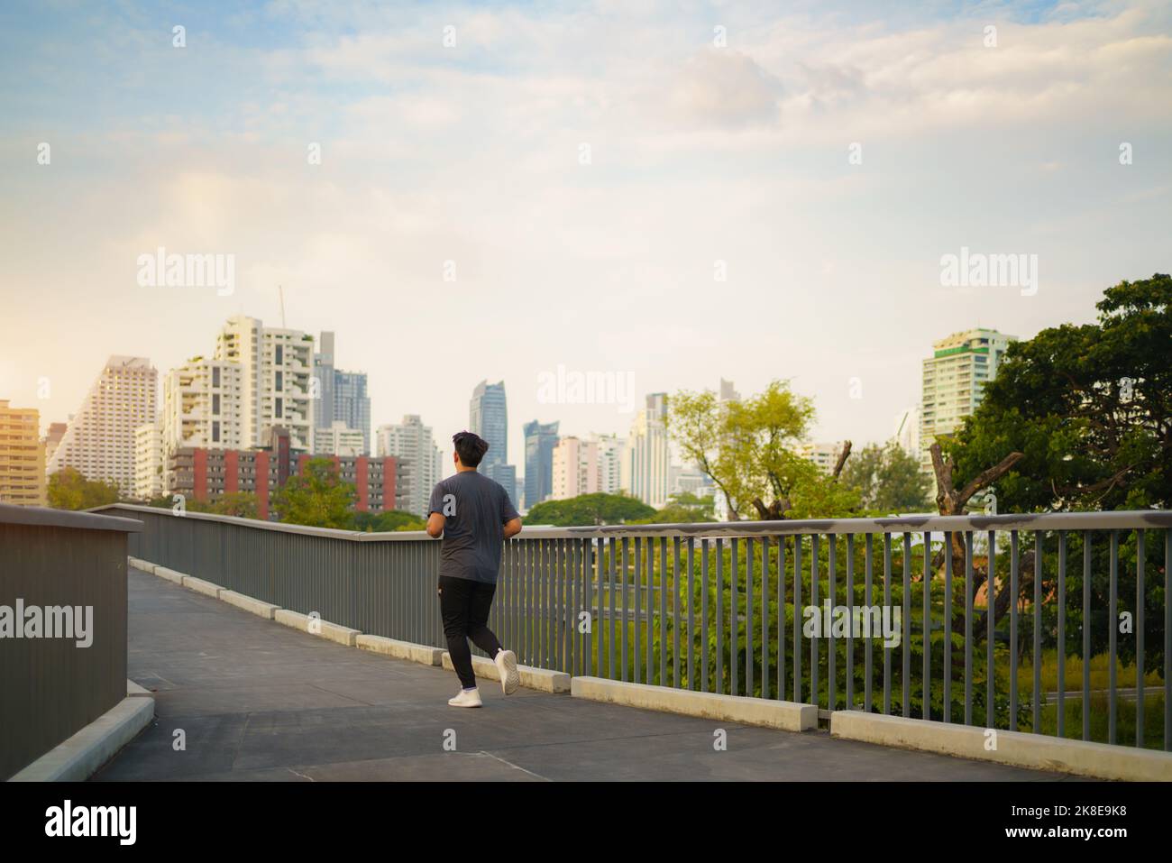 Asian healthy athlete man jogging at morning in public city park the city. Stock Photo