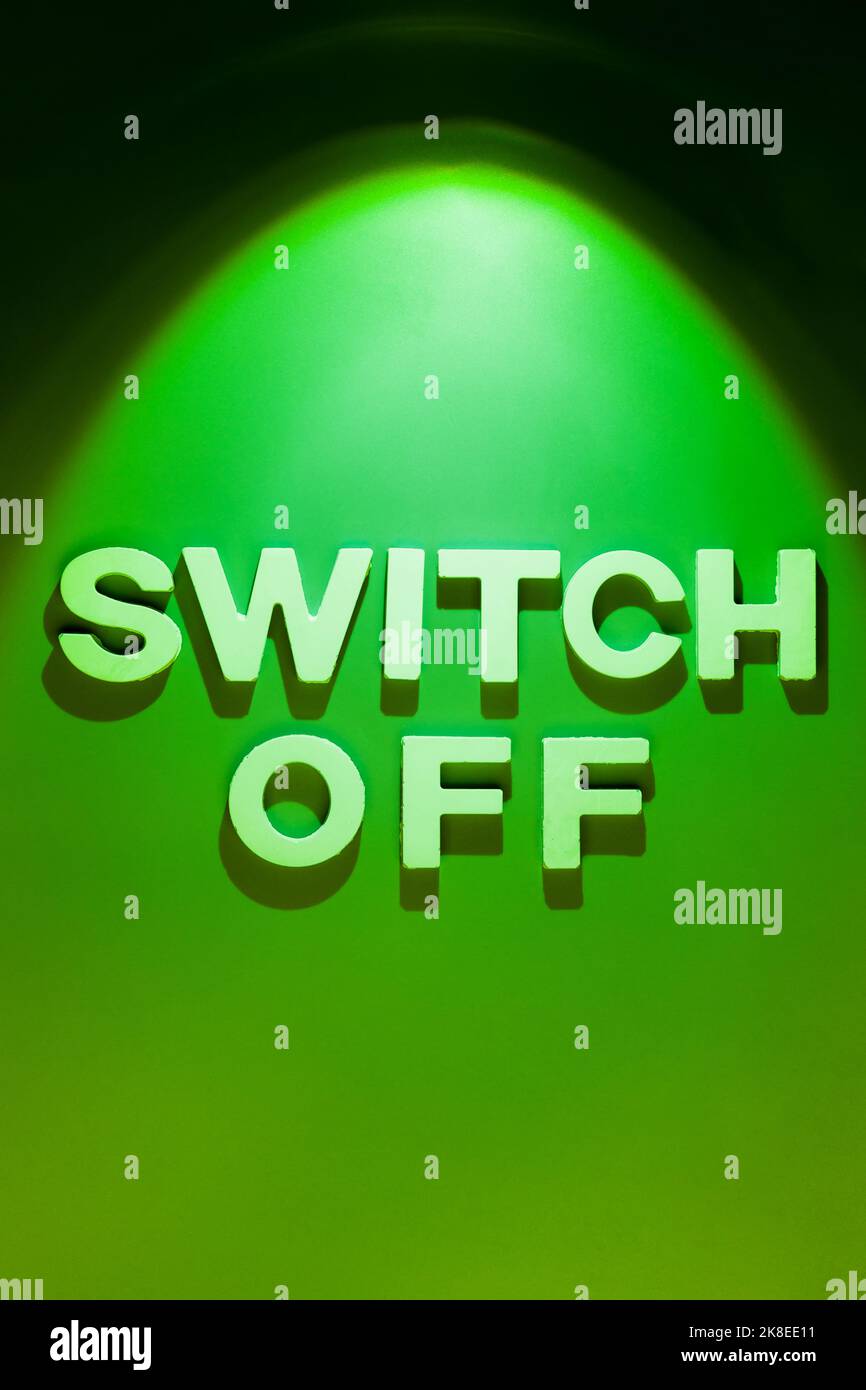 Switch Off - Text in electric light spot on green background. Energy saving concept Stock Photo