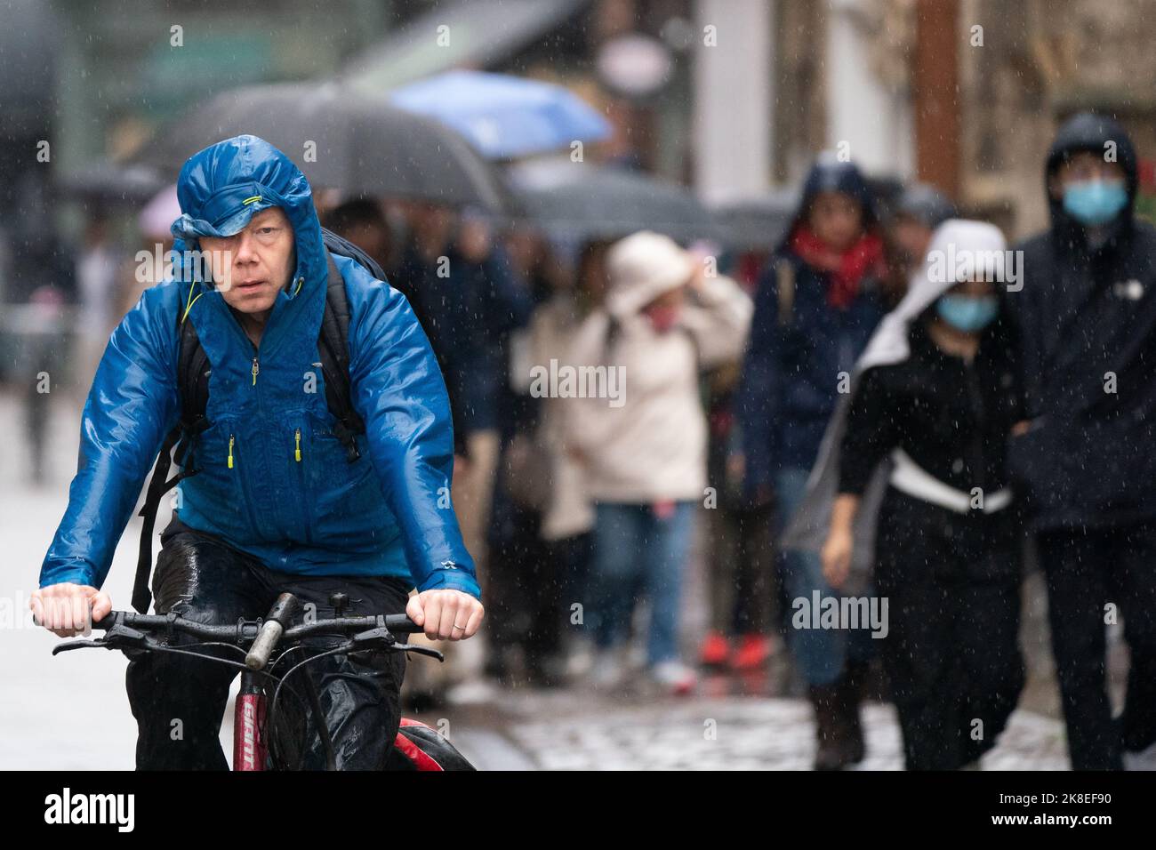 A man cycles through Cambridge in heavy rain, as a yellow weather warning is in place across much of England and parts of Wales until 5am on Monday. Picture date: Sunday October 23, 2022. Stock Photo