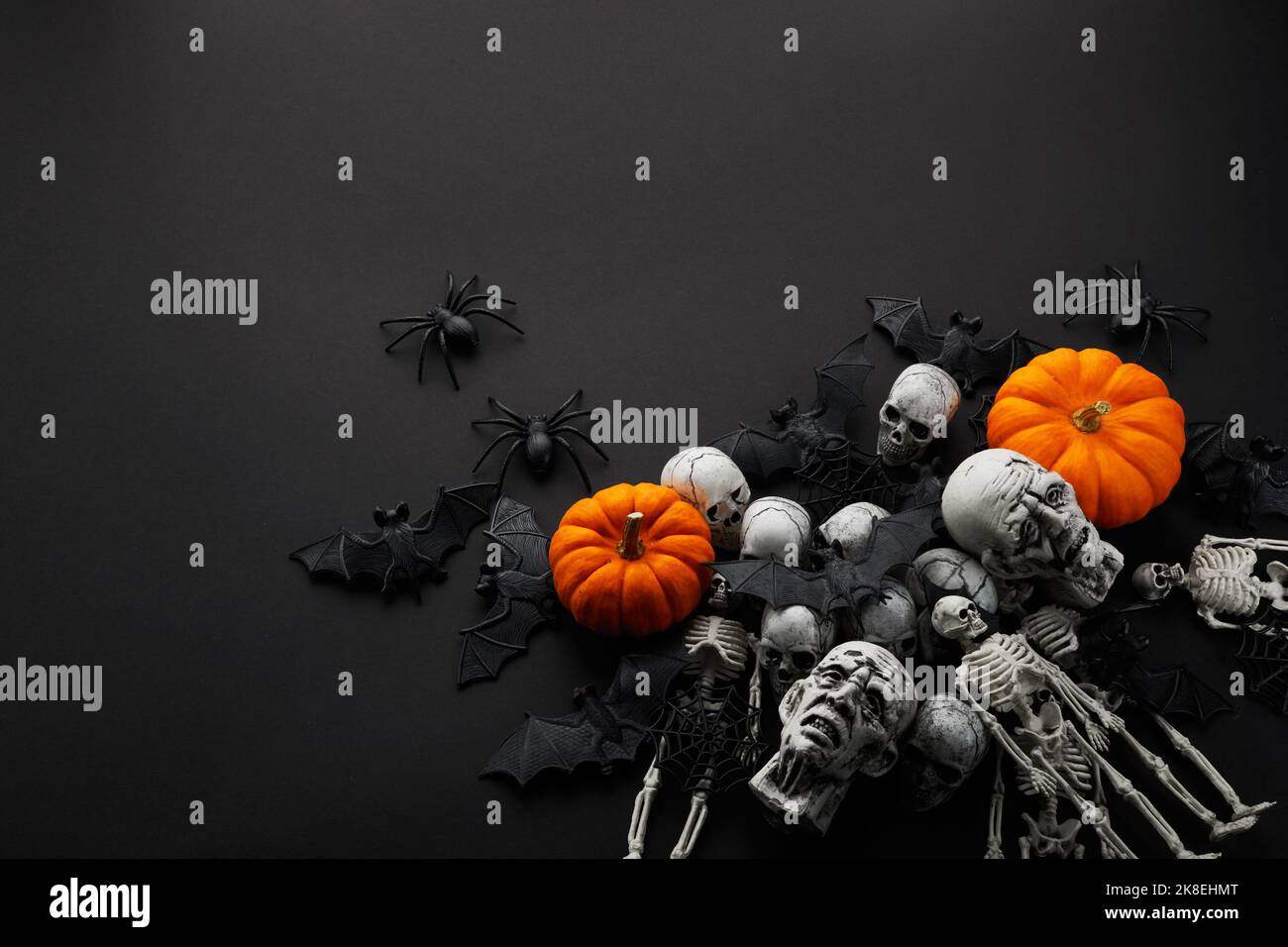 Creepy Halloween background black bats and skulls on black Stock