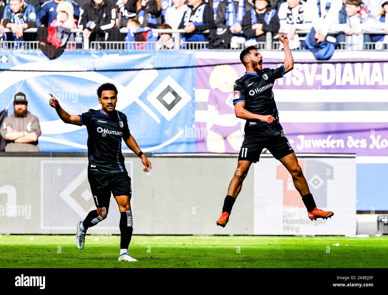 Hamburg, Germany. 23rd Oct, 2022. Soccer: 2nd Bundesliga, Hamburger SV - 1. FC Magdeburg, Matchday 13, Volksparkstadion. Magdeburg's Herbert Bockhorn (l) and Magdeburg's Mohammed El Hankouri celebrate the 0:1 goal. Credit: Axel Heimken/dpa - IMPORTANT NOTE: In accordance with the requirements of the DFL Deutsche Fußball Liga and the DFB Deutscher Fußball-Bund, it is prohibited to use or have used photographs taken in the stadium and/or of the match in the form of sequence pictures and/or video-like photo series./dpa/Alamy Live News Stock Photo