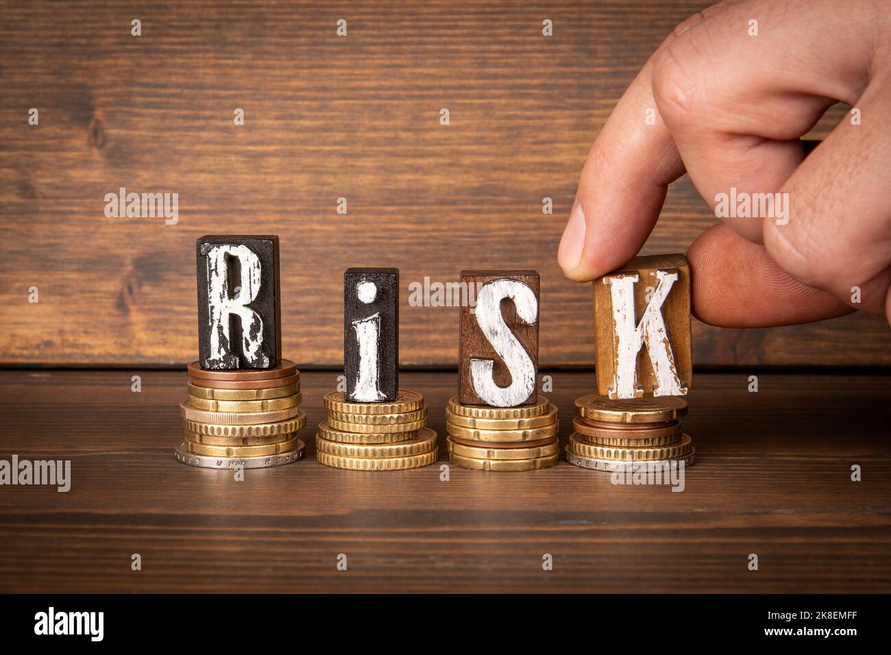Risk. Business, finance and crisis concept. Change and alphabet blocks on wooden background. Stock Photo