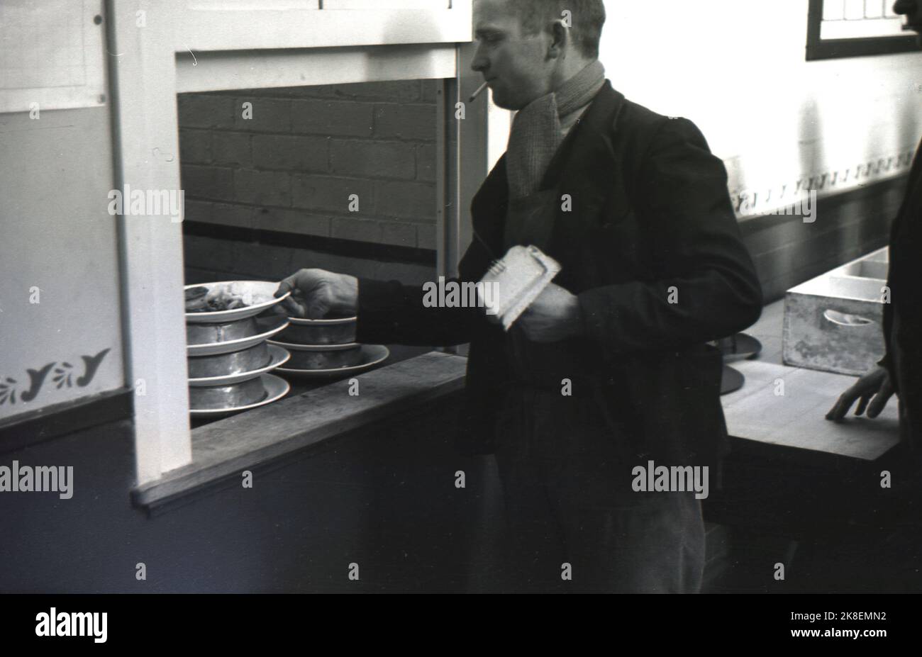 1938, historical, former mine worker at Ministry of Labour training centre at the newly establised Treforest industrial estate, collecting his lunchtime meal of pie & mash from the kitchen serving hatch of the canteen, South Wales, UK. Stock Photo