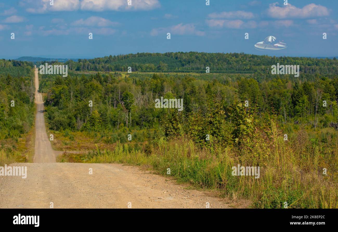 Remote dirt road with a UFO over the forest in Maine Stock Photo