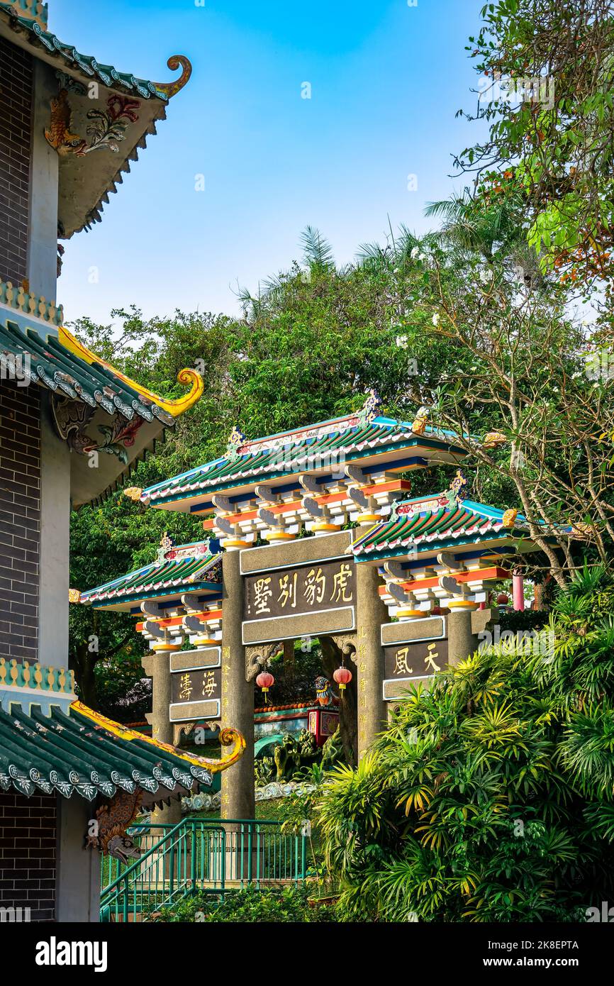 Chinese Pagoda and gateway by the Lake at Haw Par Villa. This park has statues and dioramas scenes from Chinese mythology, folklore,legend and history Stock Photo