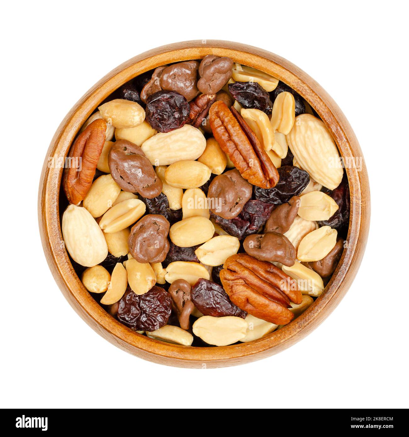 Nut and berry mix, with milk chocolate, in wooden bowl. Sweet snack food of roasted pecans, almonds, peanuts, dried cranberries and chocolate. Stock Photo