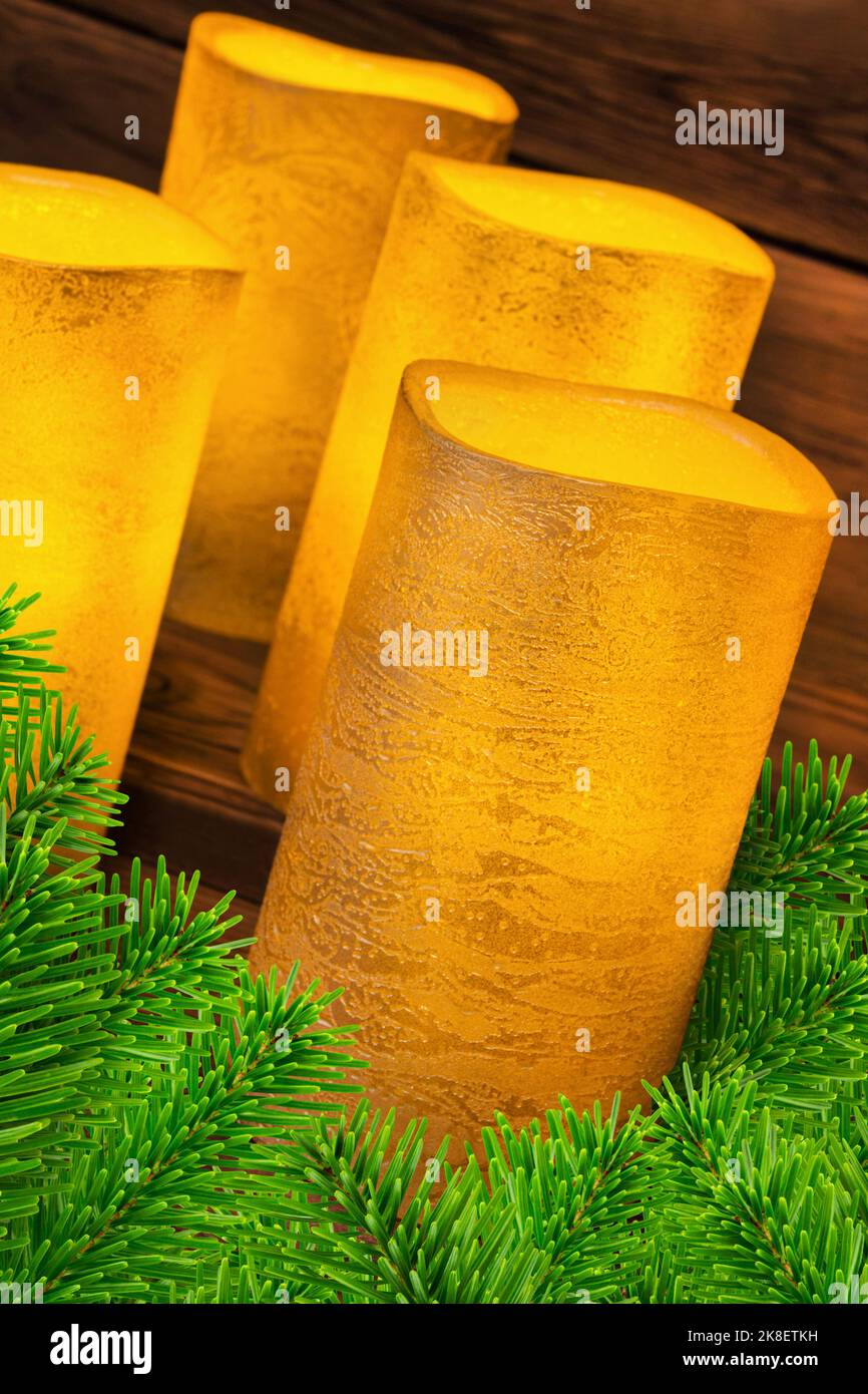 Four golden vintage LED real wax candles and fir branches Stock Photo