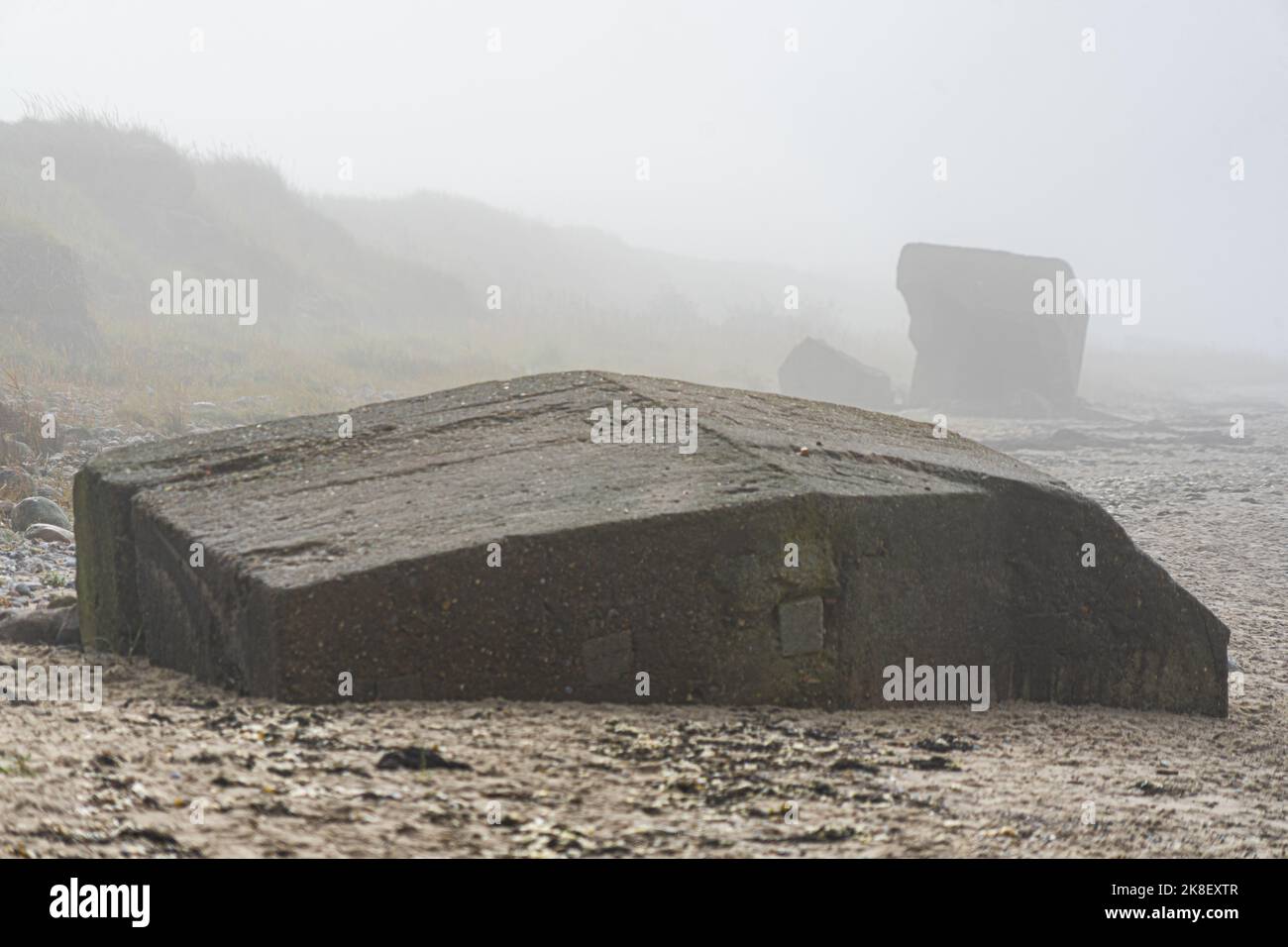 Old German coastal fortifications rotting on a beach in the morning mist Stock Photo