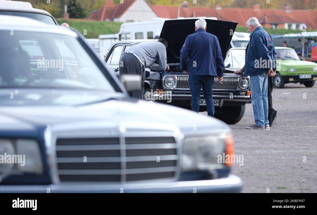 Halle, Germany. 23rd Oct, 2022. Visitors of the fair 'Oldtema Hall 2022' talk shop at a Russian car of the brand 'Volga', in the front is a Mercedes S-class, in the background a Wartburg 353. At the weekend, parts market for old cars and motorcycles took place. Credit: Sebastian Willnow/dpa/Alamy Live News Stock Photo