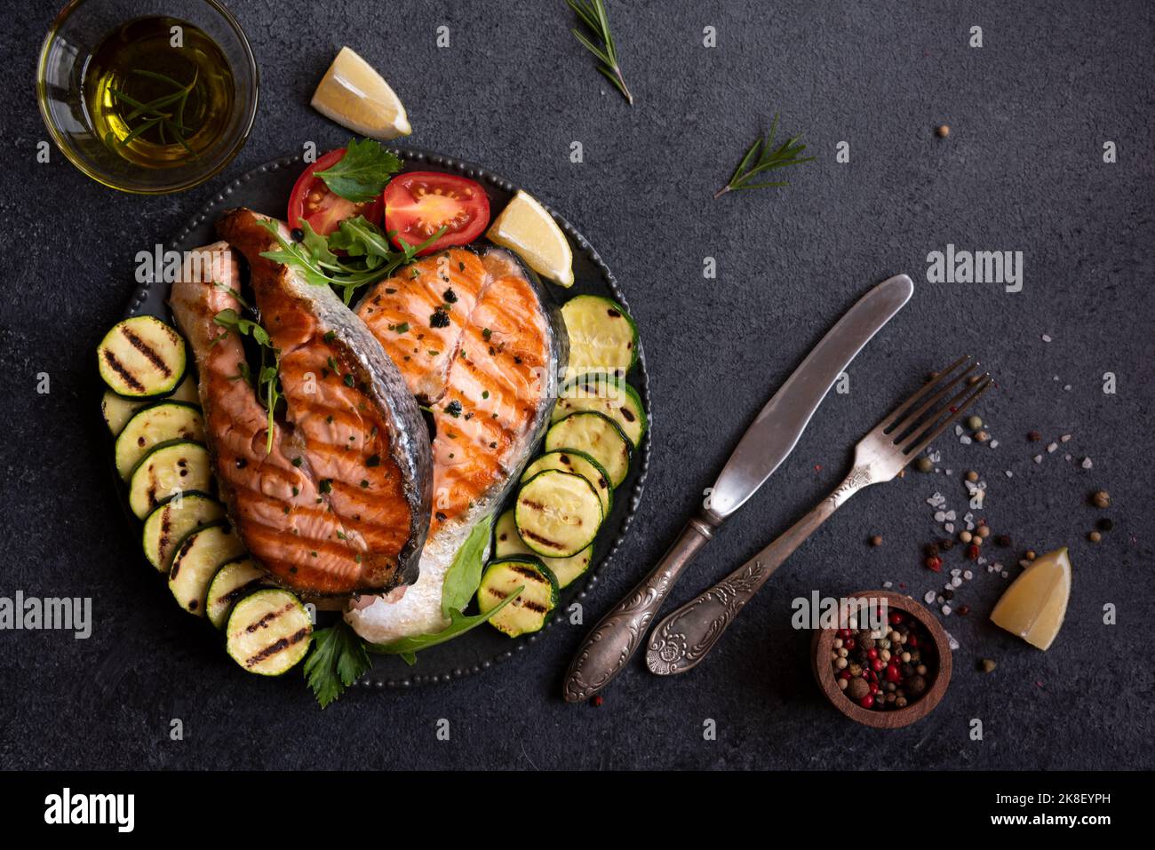 Cooked salmon fish with vegetables on dark background Stock Photo