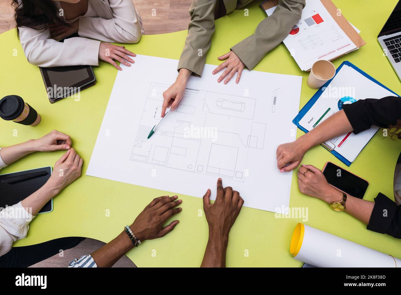 Architect explaining floor plan to colleagues on table Stock Photo - Alamy