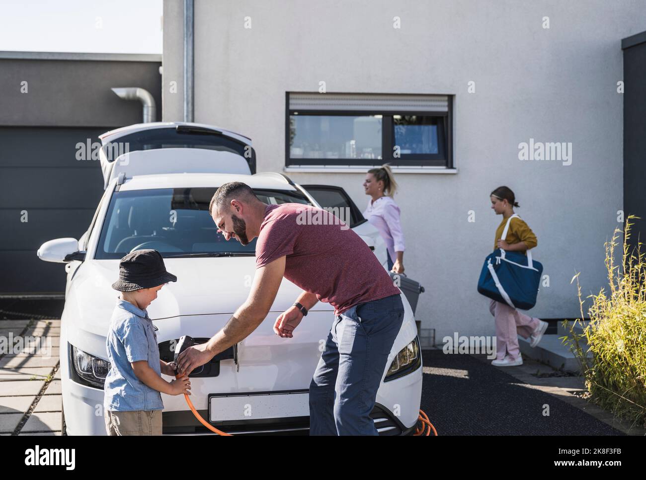 Father and son charging electric car for family vacation Stock Photo