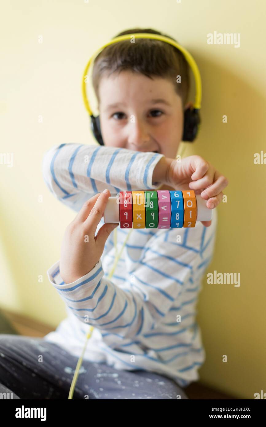 Boy showing arithmetic cylindrical cube toy Stock Photo