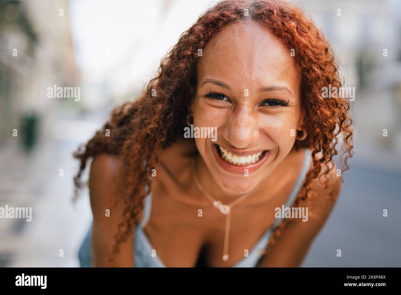 Cheerful young woman with curly hair Stock Photo