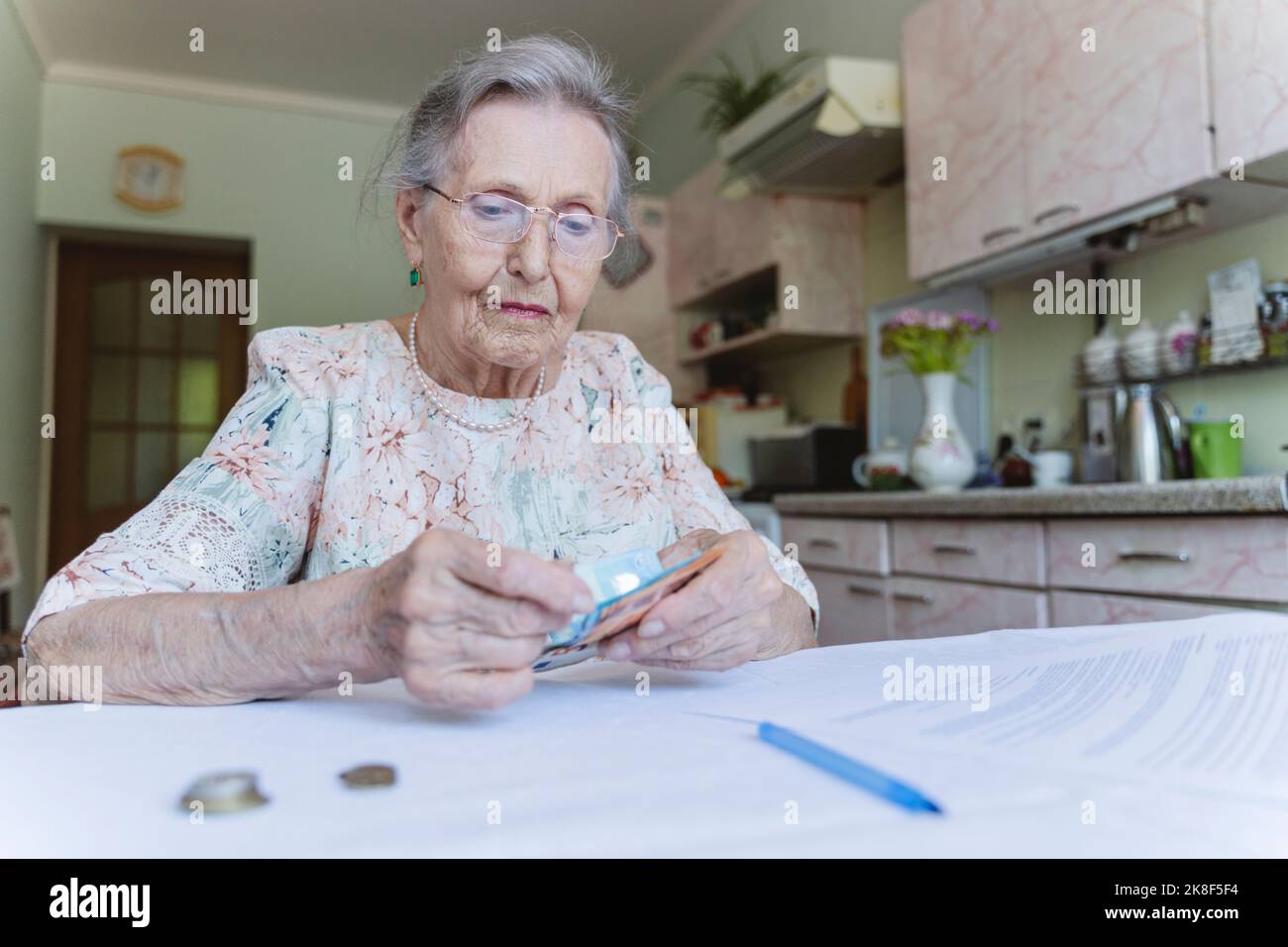 Senior woman counting paper currency at home Stock Photo