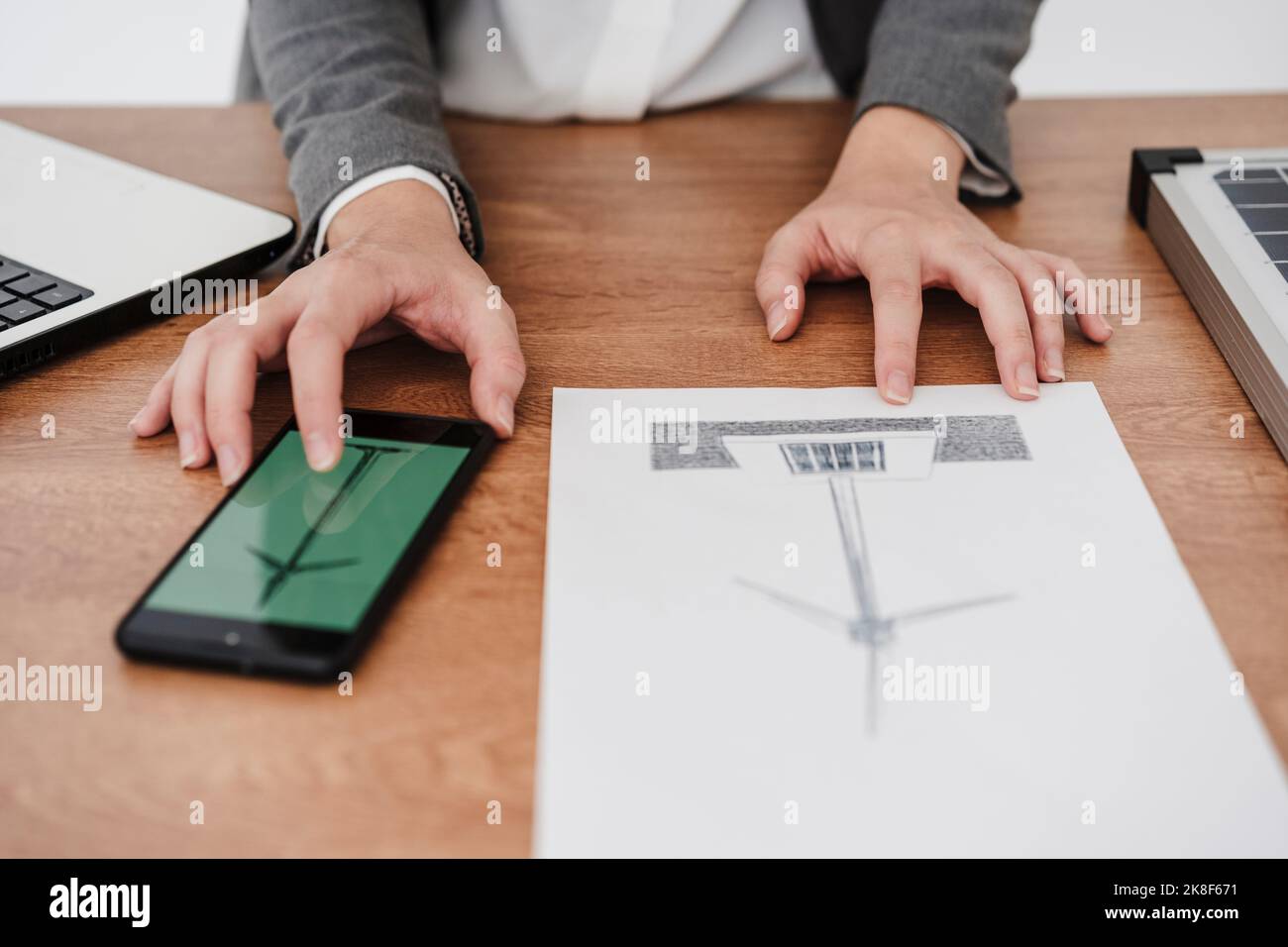 Female engineer working on windturbine model using smartphone Stock Photo