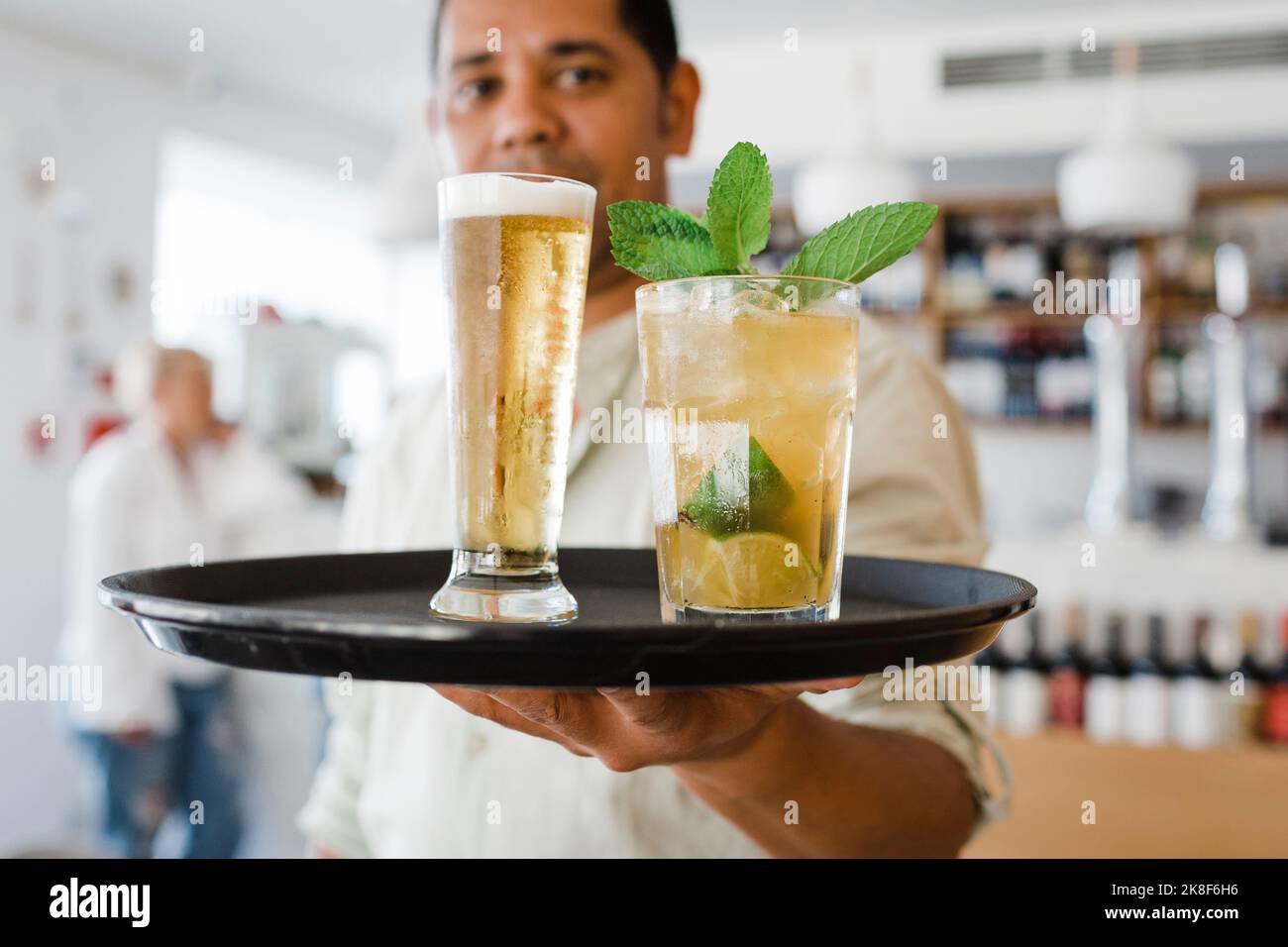 Waiter with tray serving drinks at restaurant Stock Photo