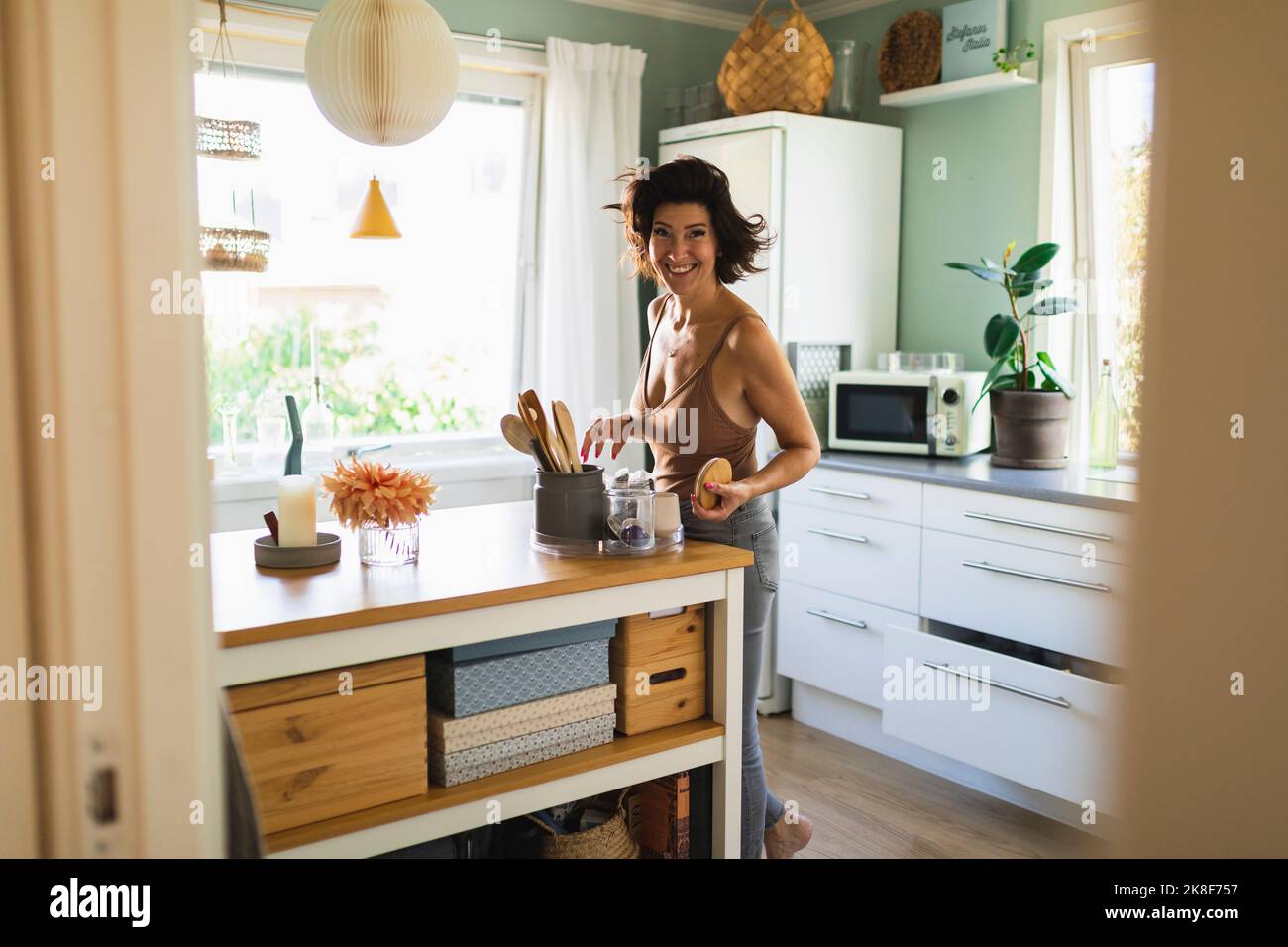 Smiling mature woman at kitchen island Stock Photo