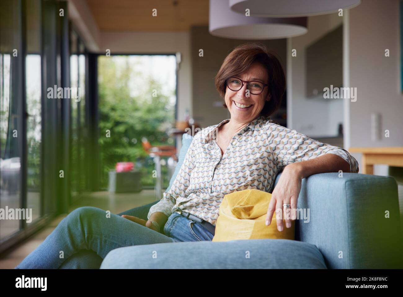 Senior woman sitting on sofa hi-res stock photography and images - Alamy