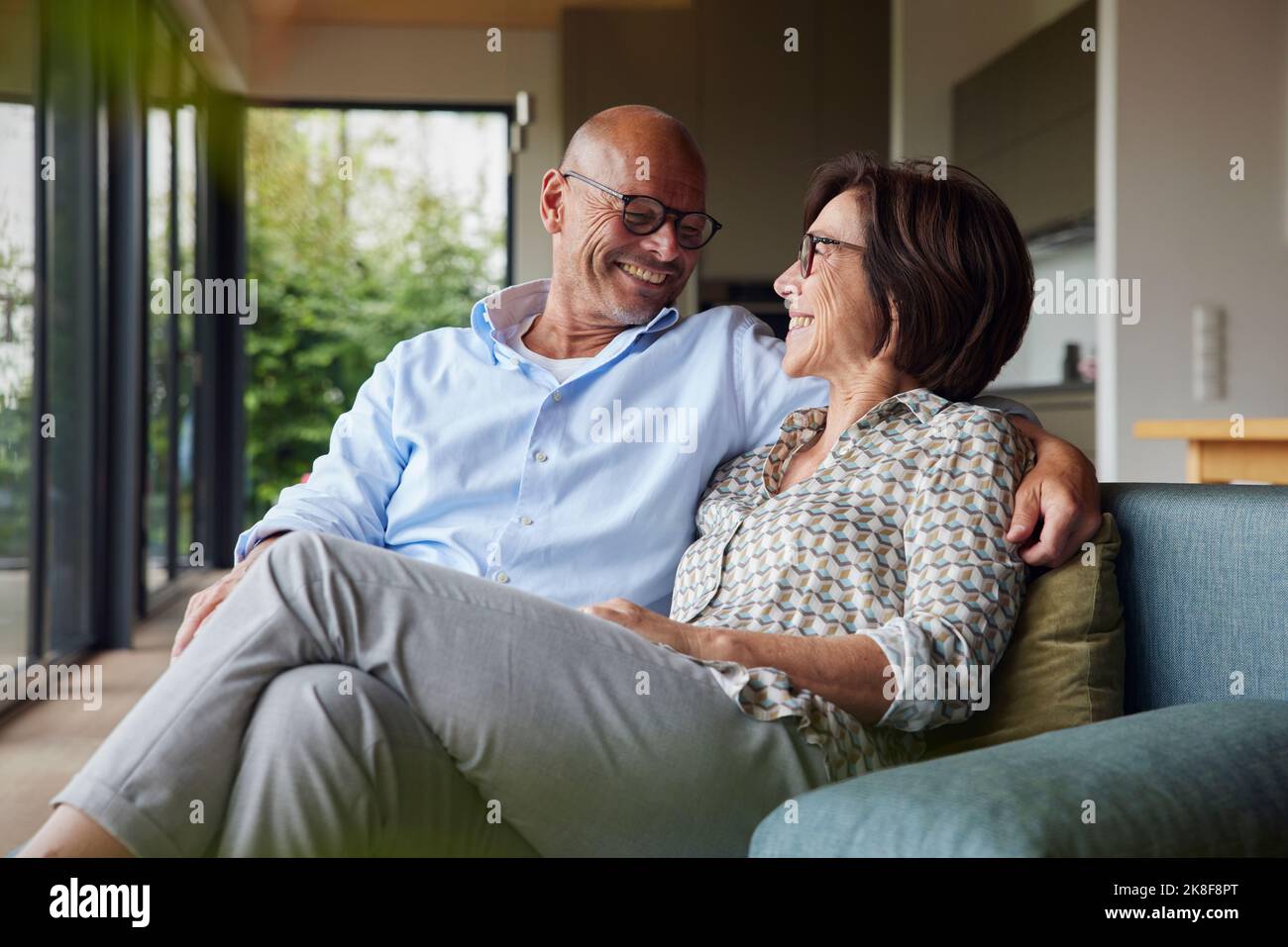 Loving senior couple sitting on sofa at home Stock Photo