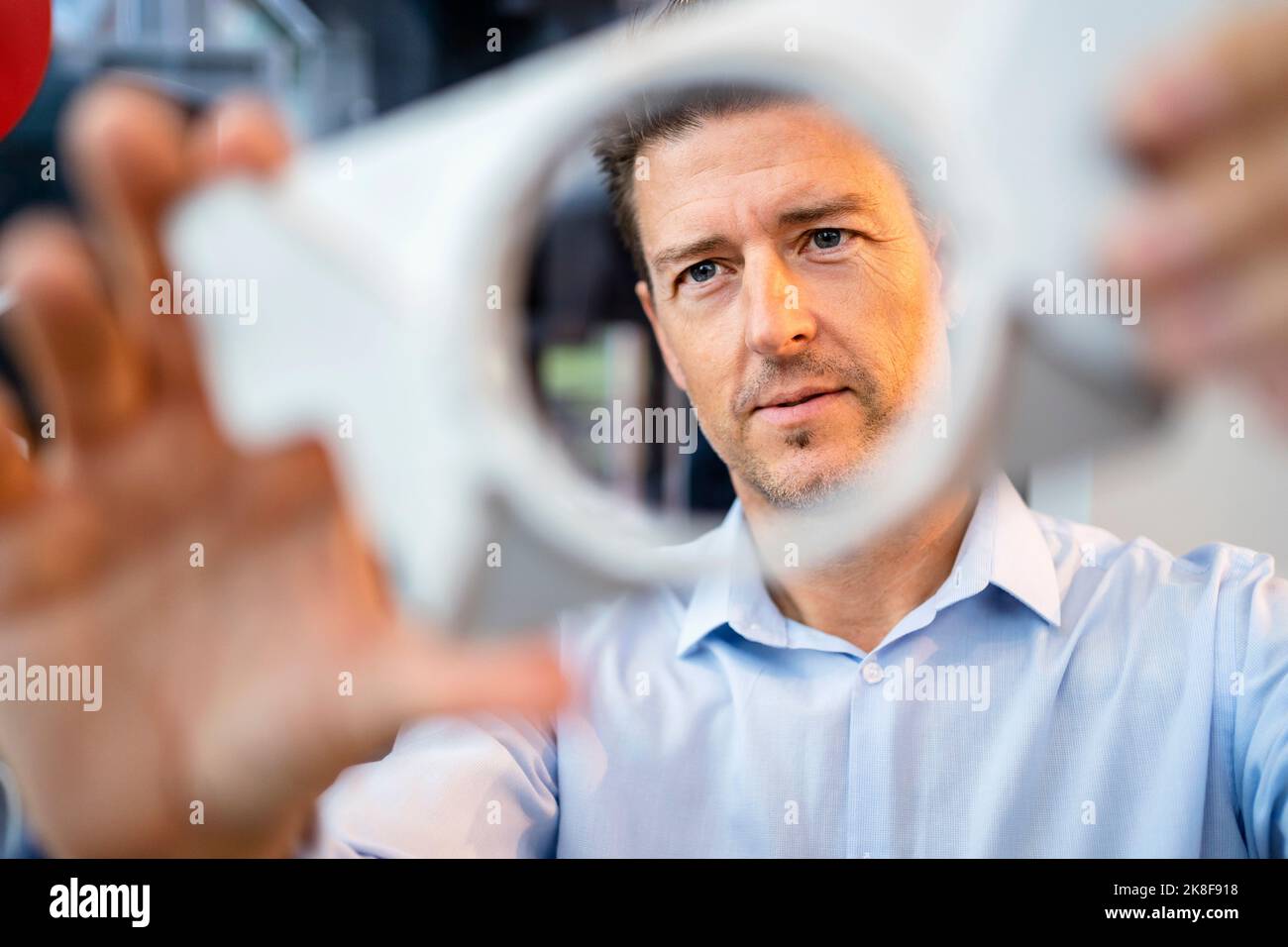 Engineer analyzing machine part working at factory Stock Photo - Alamy