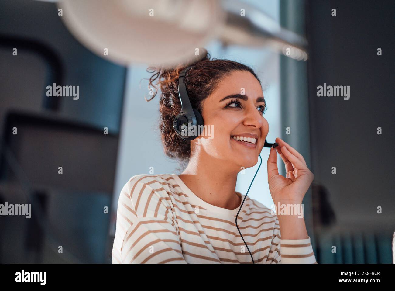 Customer service representative talking on headset in office Stock Photo