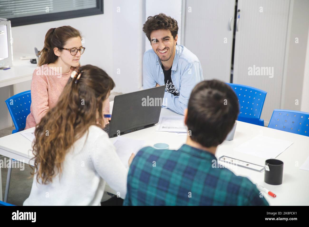 Smiling businessman talking to multiracial colleagues in office Stock Photo