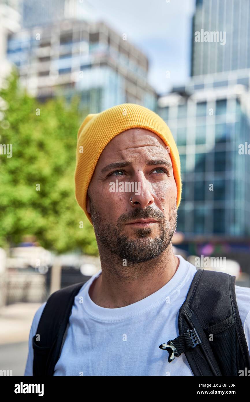 Man with beard wearing yellow knit hat Stock Photo
