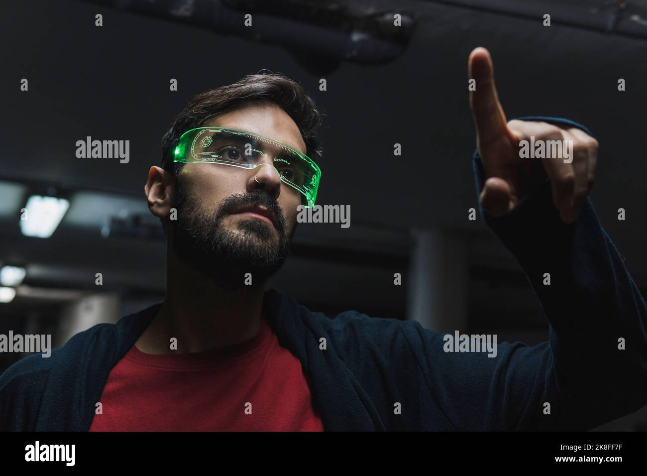 Man wearing futuristic smart glasses touching augmented interface Stock Photo