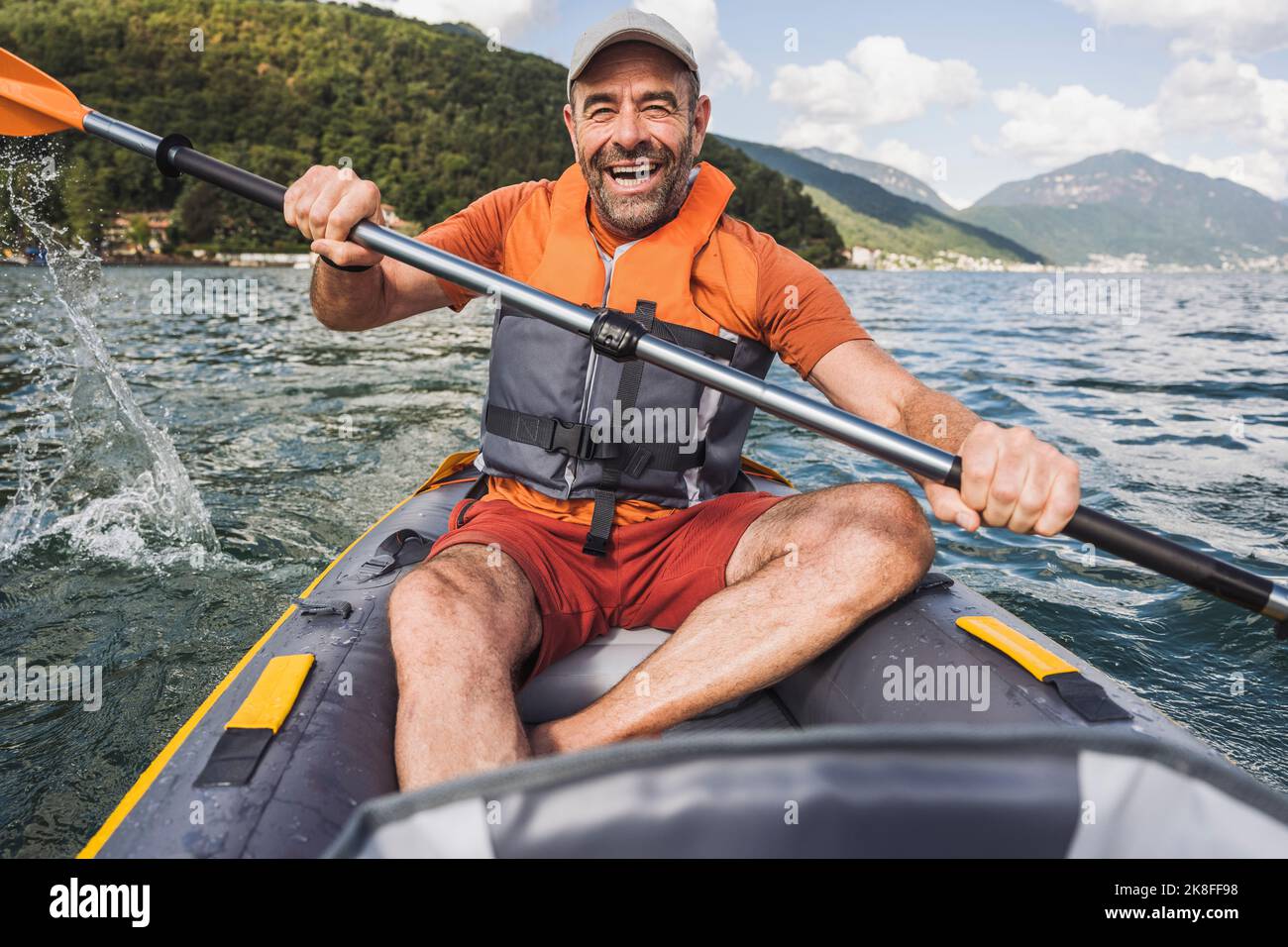 Happy man in life jacket rowing kayak boat at lake Stock Photo Alamy