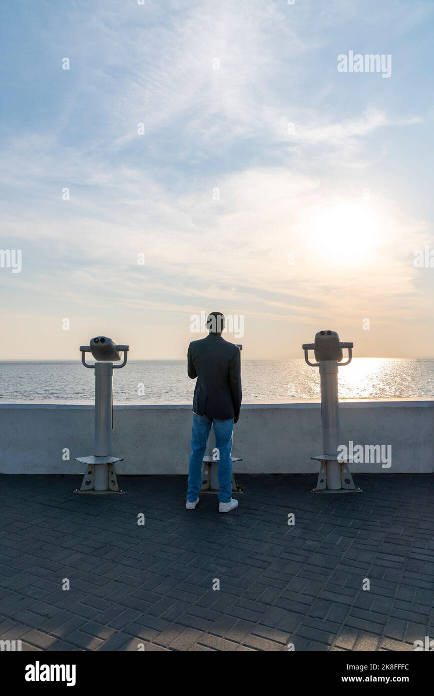 Young businessman on footpath at sunset Stock Photo
