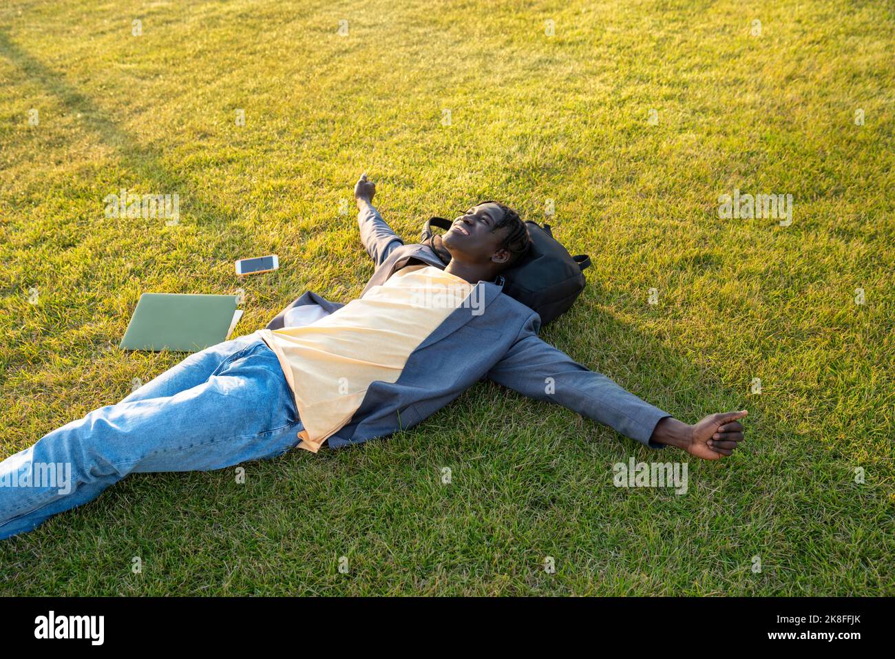 Top view of man lying down on grass with laptop Stock Photo - Alamy