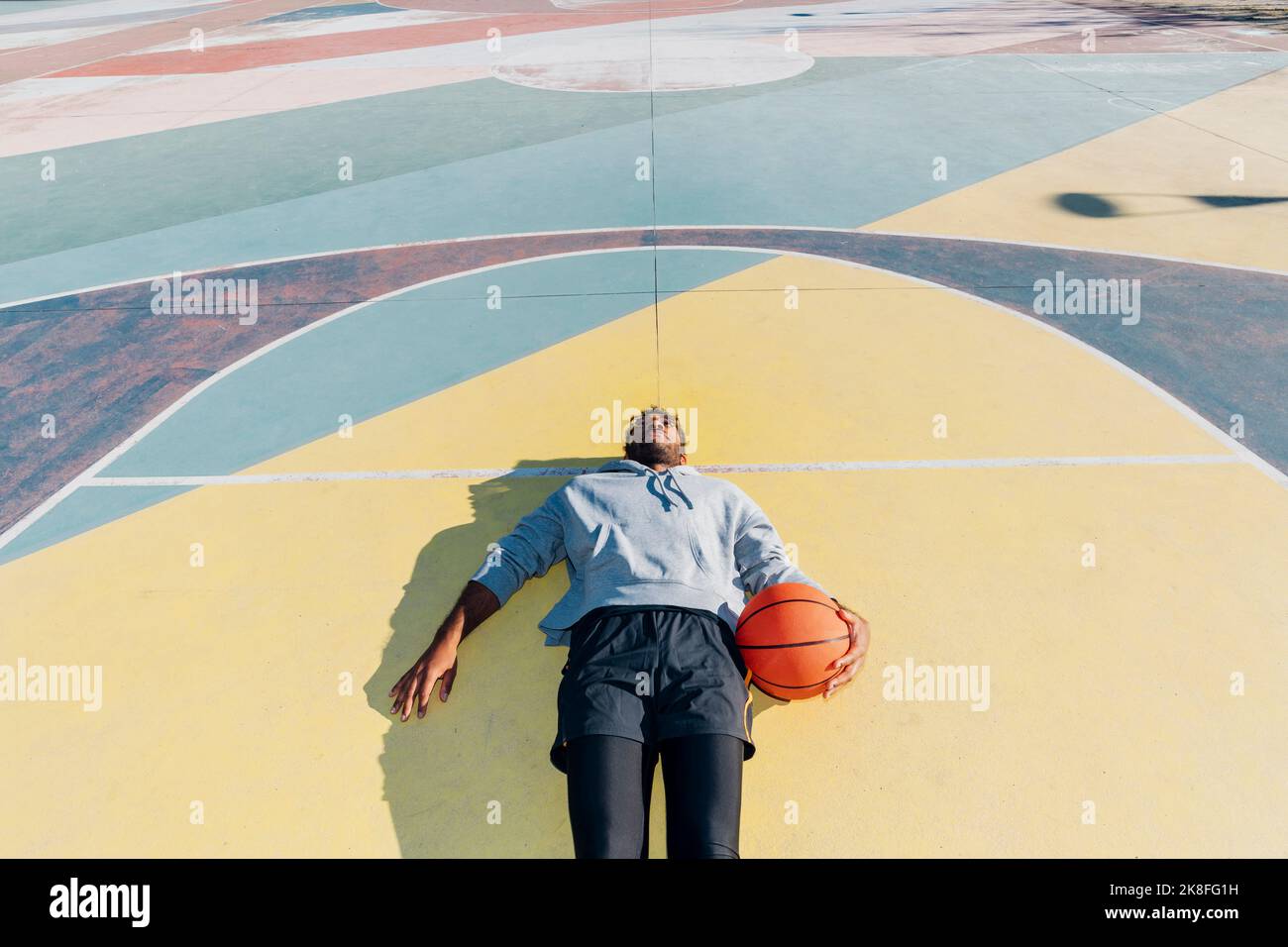 Tired basketball player lying on court Stock Photo - Alamy