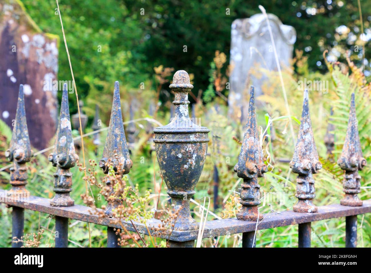 Close up on a old wrought iron fence top fitted with cast railhead points and cast iron urn Stock Photo