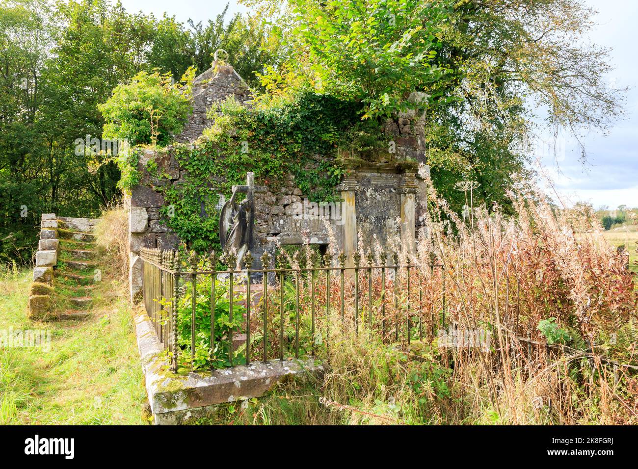 Springkell, Scotland - September 28 2022 : Springkell Old Parish Church ruins overgrown with ivy, bushes and weeds Stock Photo