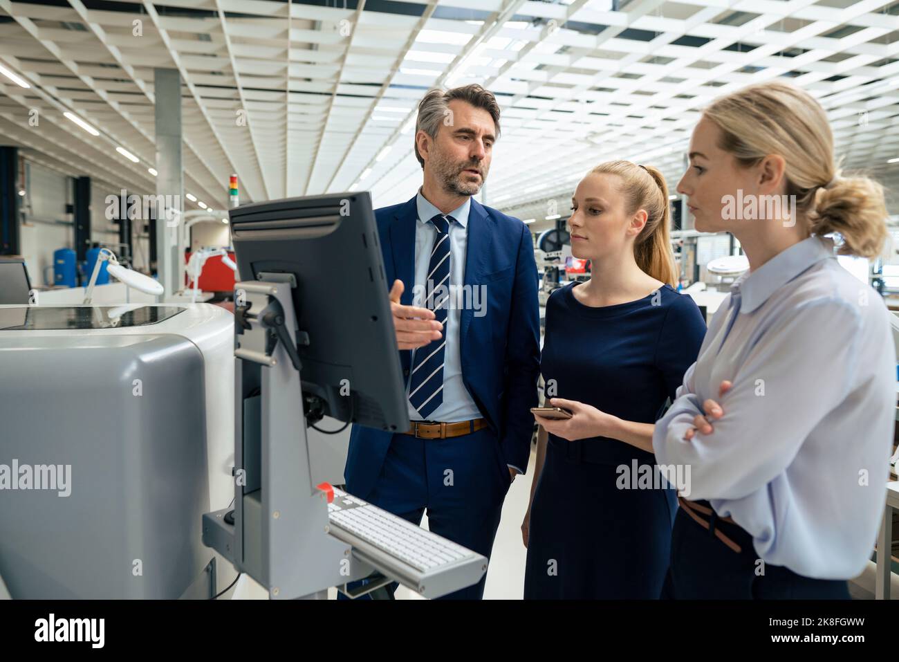 Mature businessman having discussion with colleagues over desktop ...