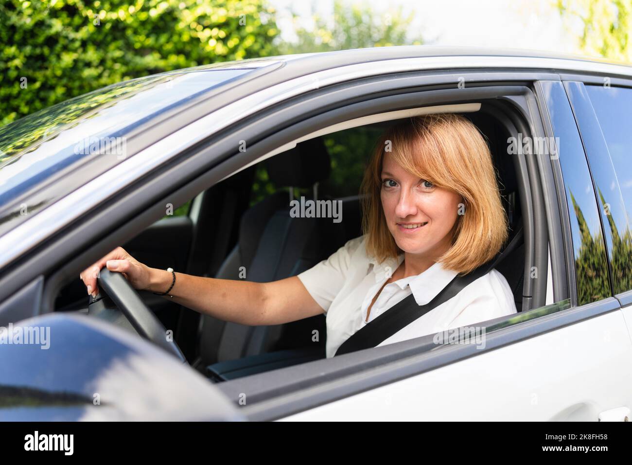 Smiling mature woman driving car Stock Photo