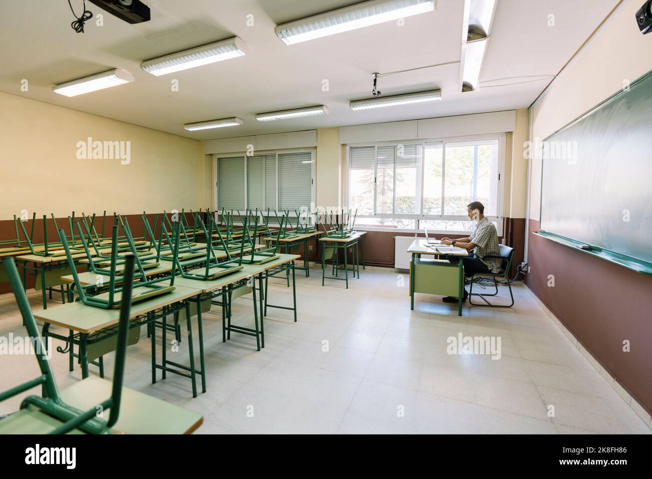 Math teacher sitting in empty classroom Stock Photo