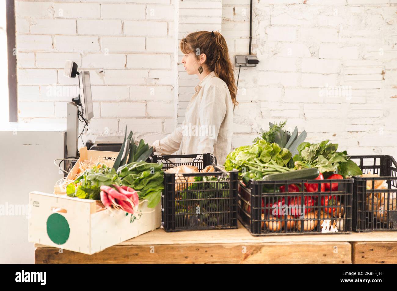 Grocer using weight scale in greengrocer shop Stock Photo