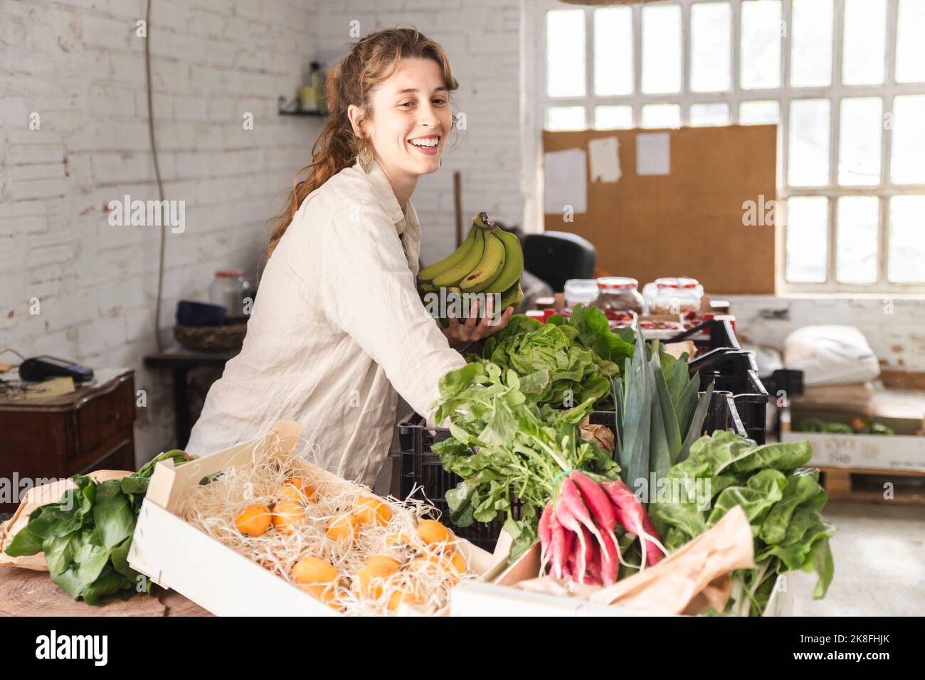 Happy owner picking up vegetables in greengrocer shop Stock Photo