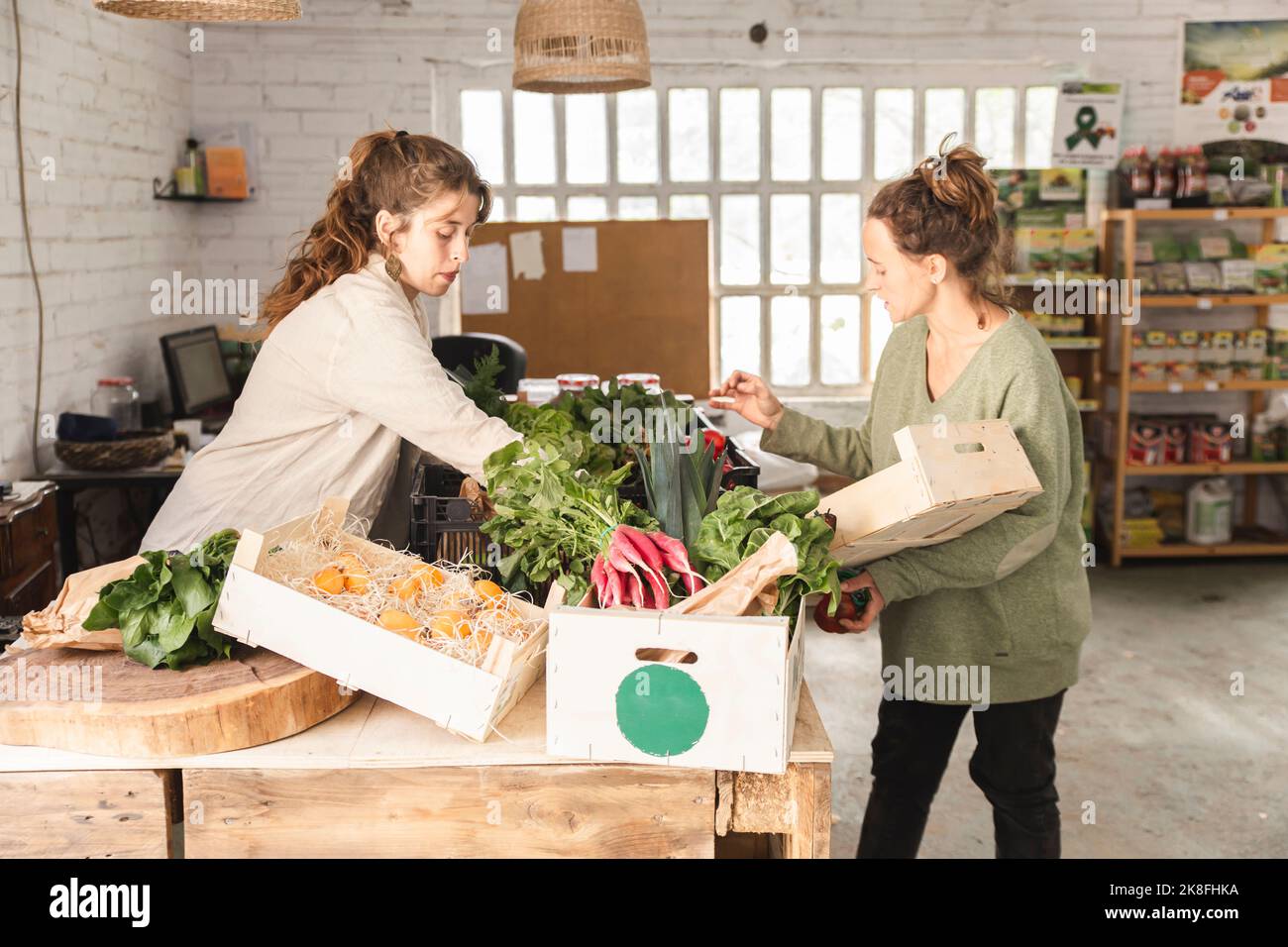 Owner assisting customer buying vegetables in greengrocer shop Stock Photo