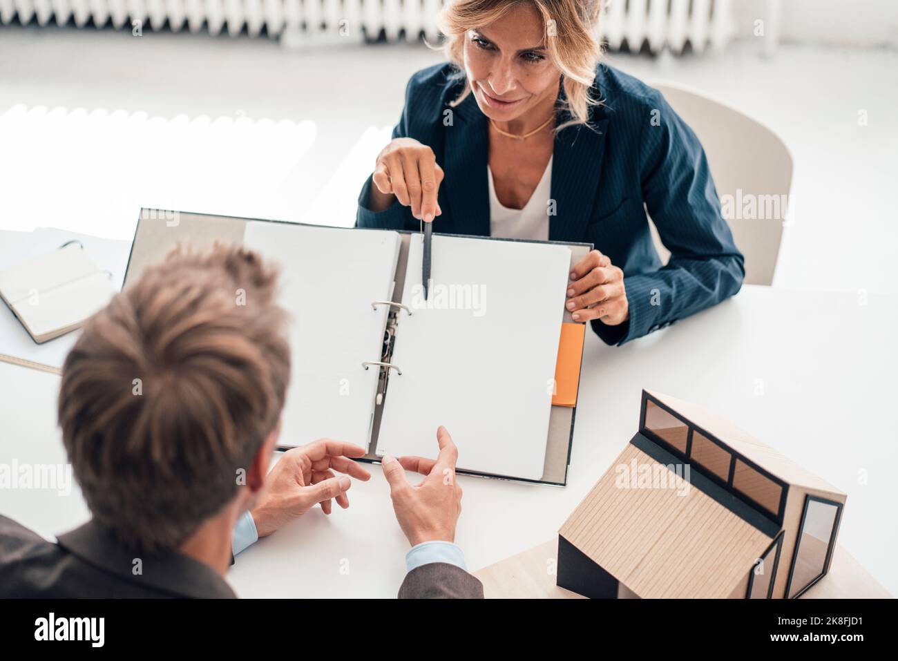 Real estate agent showing documents to customer at office Stock Photo