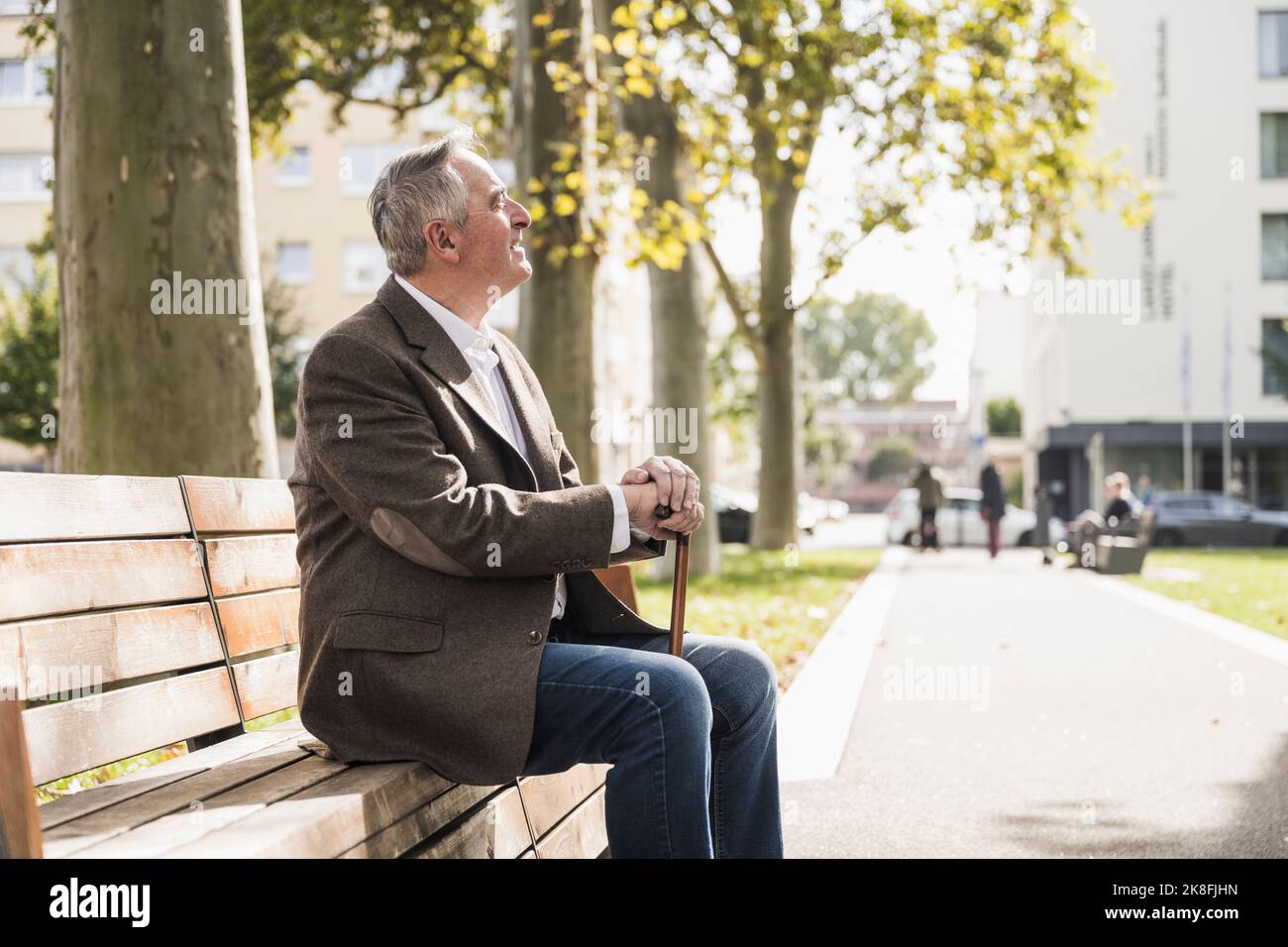 Senior man with walking cane sitting on bench Stock Photo - Alamy