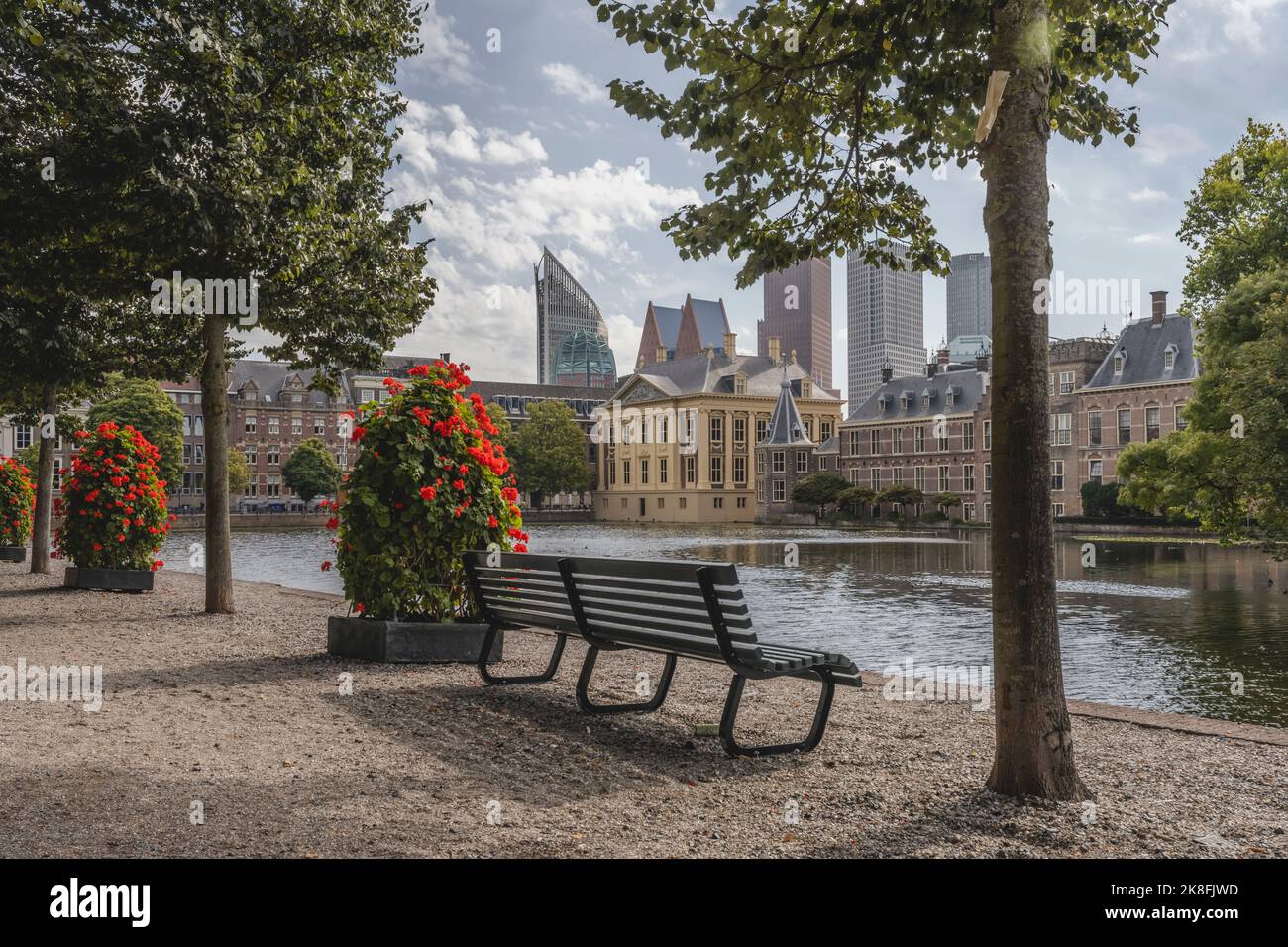 Netherlands, South Holland, The Hague, Park bench in front of Hofvijver lake canal with Mauritshuis museum in background Stock Photo